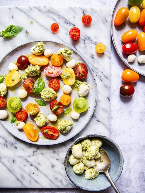 Top down of a plate of caprese salad with basil pesto