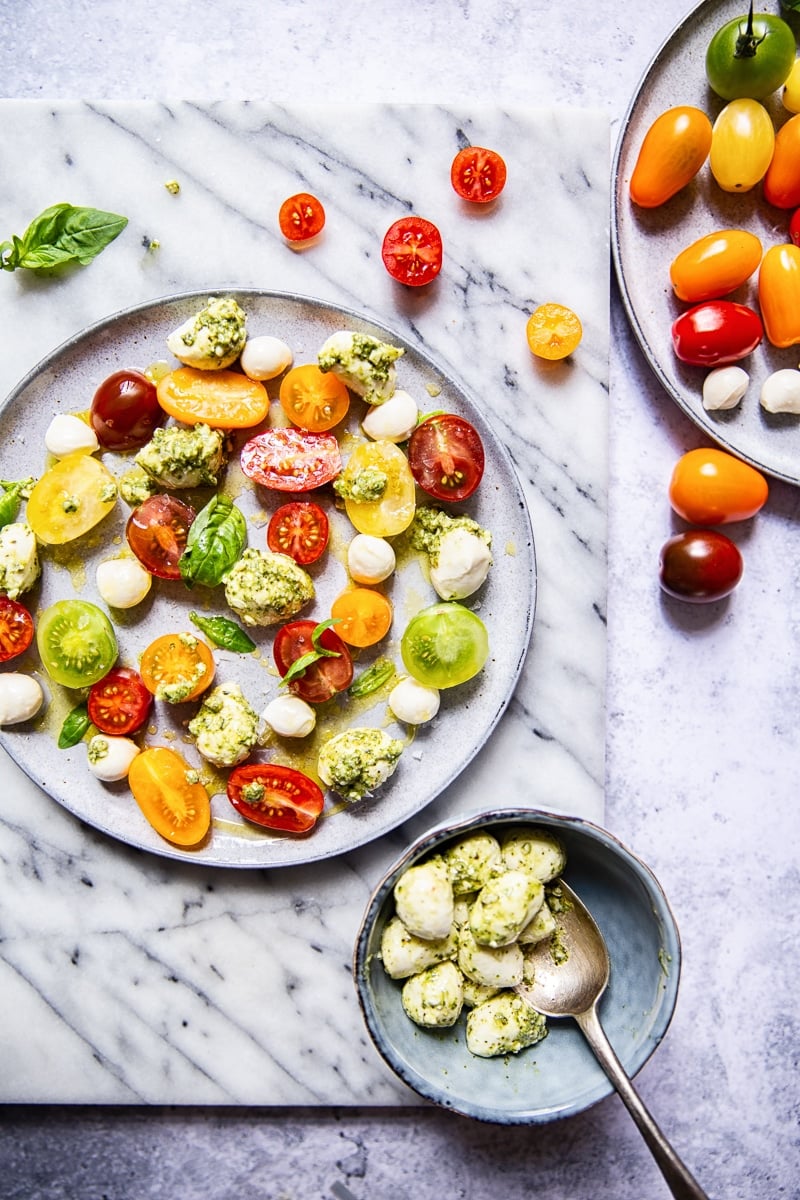 Top down of a plate of caprese salad with basil pesto