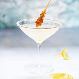 Side shot of sugar coated stir stick dipping into Lemon Drop Martini