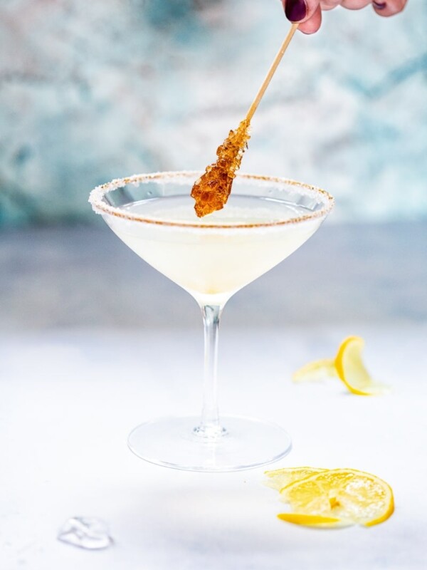 Side shot of sugar coated stir stick dipping into Lemon Drop Martini