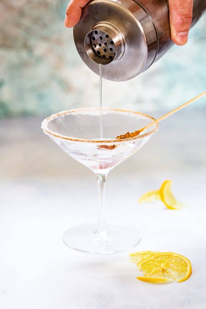 Close up of lemon drop martini pouring into martini glass