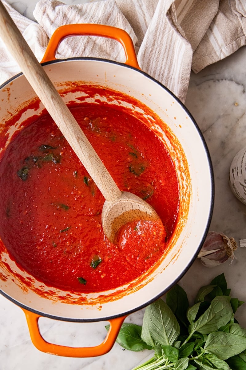 Pot with spaghetti sauce and a wooden spoon