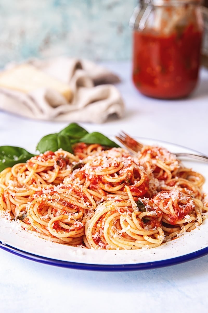 Plate of pasta with a jar in the background