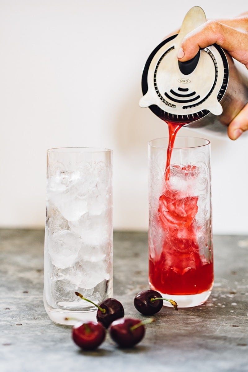 Drink being poured over ice into glasses with cocktail shaker