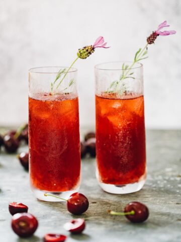 cherry long island iced tea in glasses with flower garnish