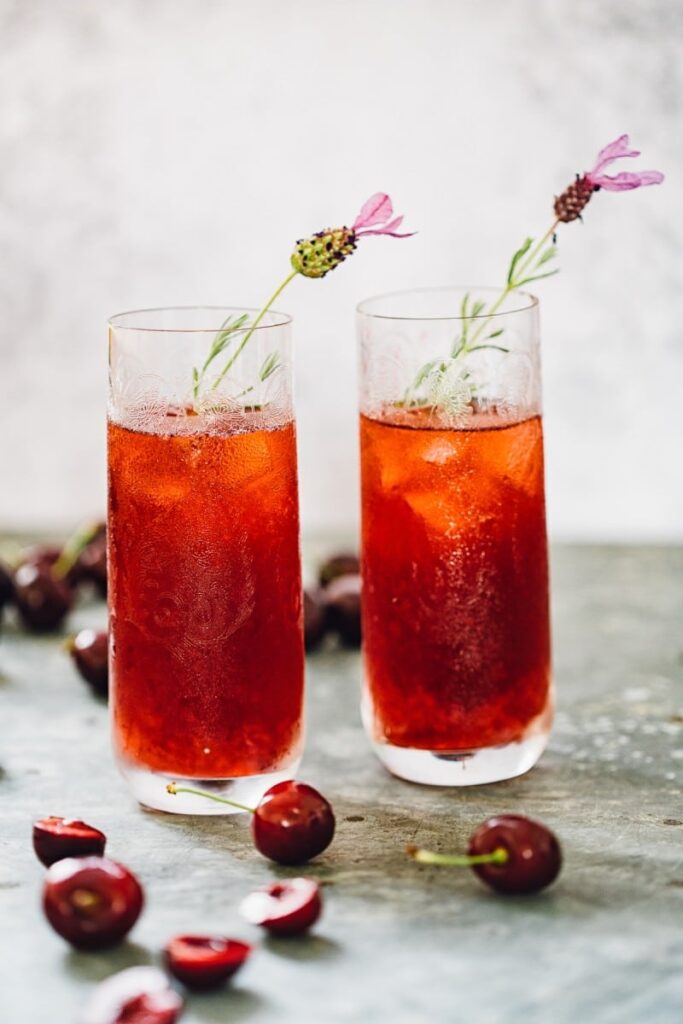 cherry long island iced tea in glasses with flower garnish
