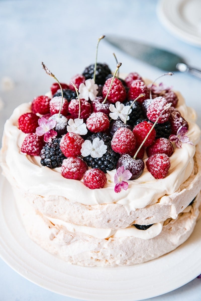 Looking down on pavlova with berries and flowers on top