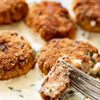 Close up of a piece of salmon fishcake held by a fork