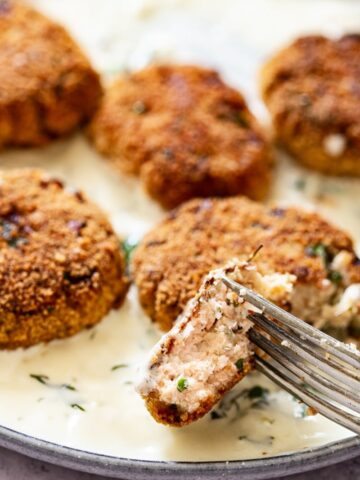 Close up of a piece of salmon fishcake held by a fork