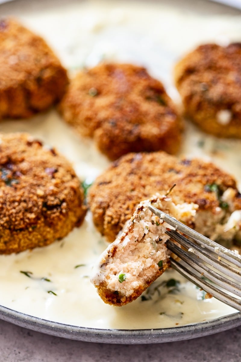 Close up of a piece of salmon fishcake held by a fork