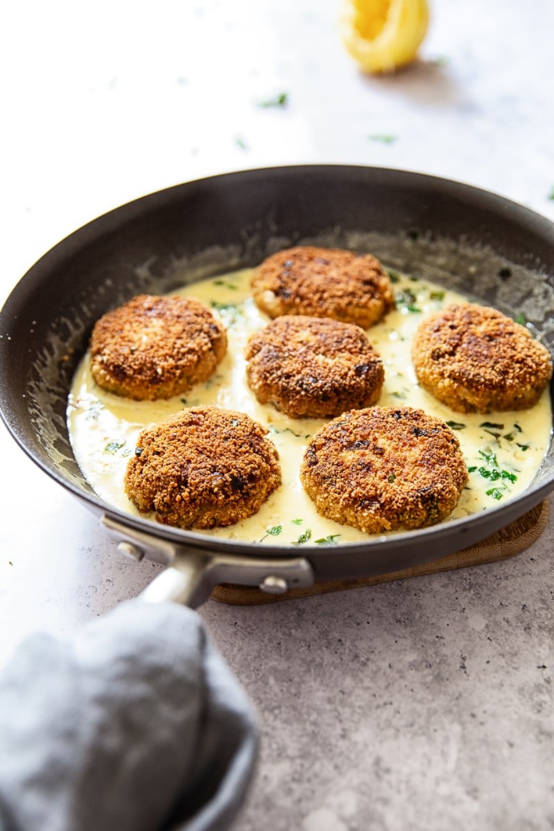 Fry pan with six salmon fishcakes from the side