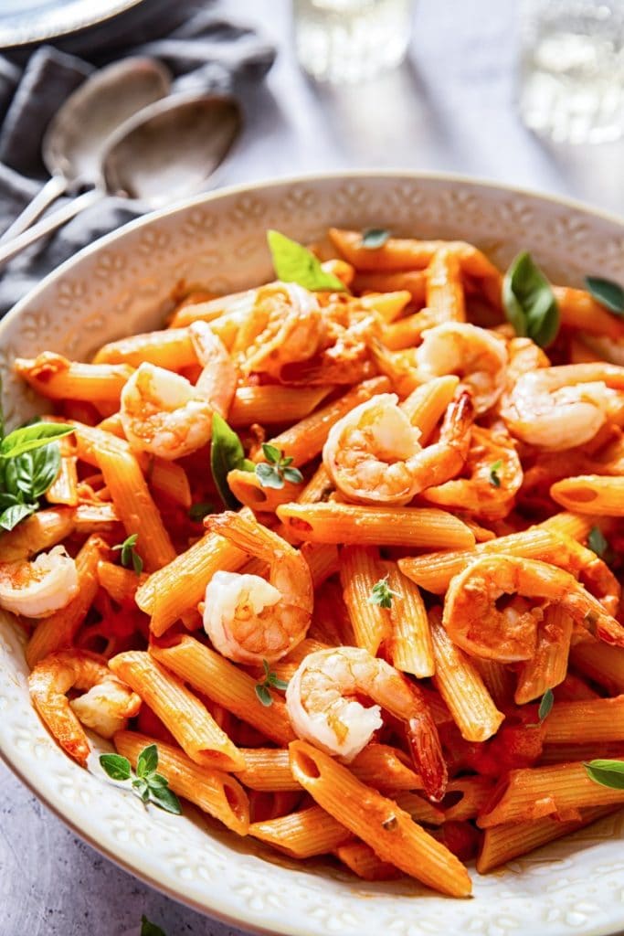 Side view of a serving bowl of penne alla vodka with shrimp