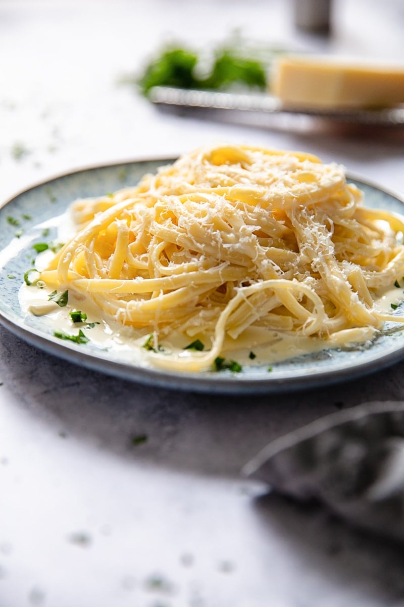 Side view of a plate of pasta in cream sauce