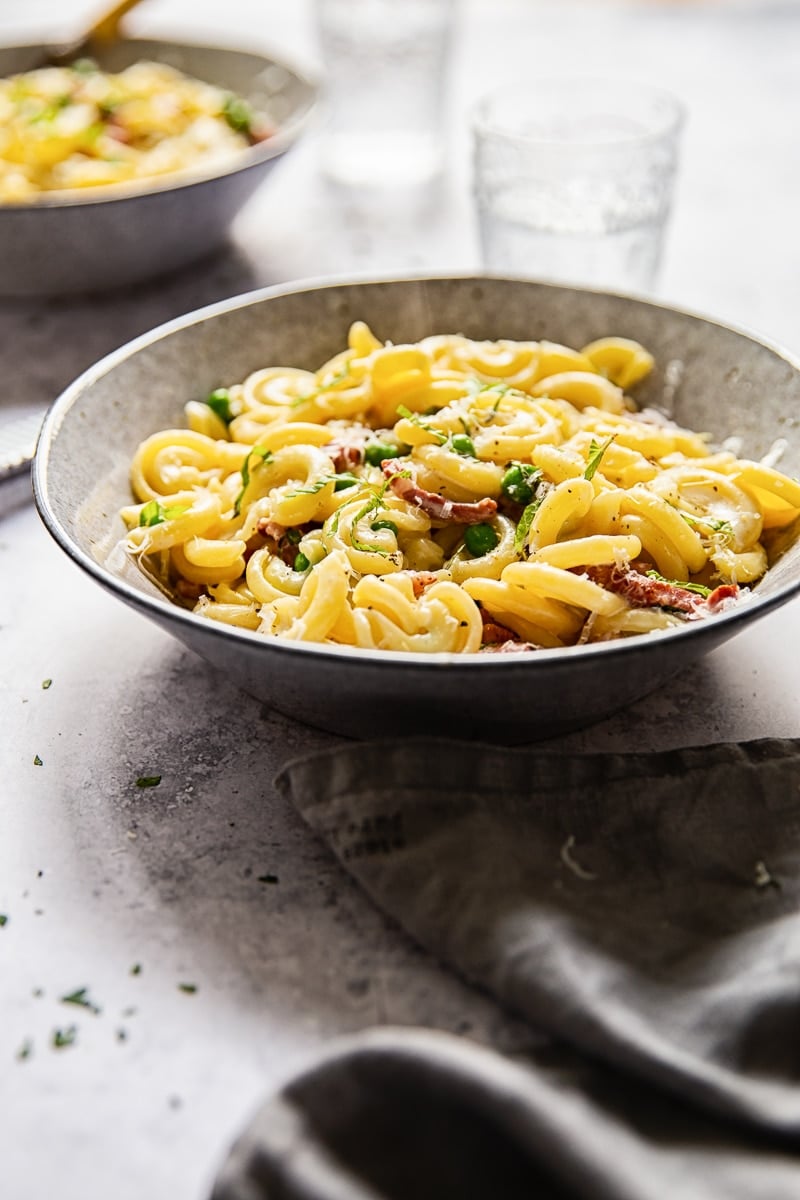 Bowl of pasta with glasses and a towel