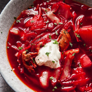 close up of a bowl of borscht with a dollop of sour cream