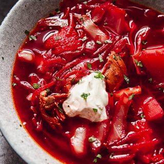 close up of a bowl of borscht with a dollop of sour cream