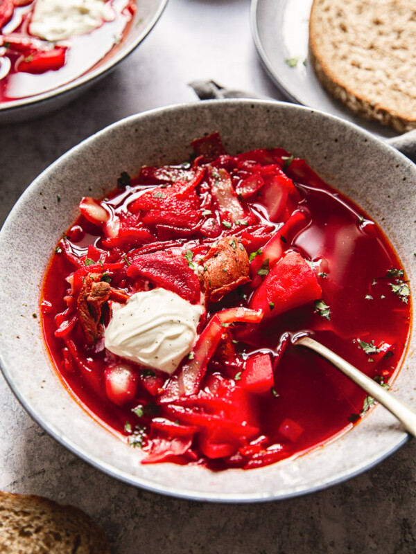 Borscht in a bowl with a spoon and dollop of sour cream