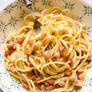 Bowl of spaghetti carbonara with a fork