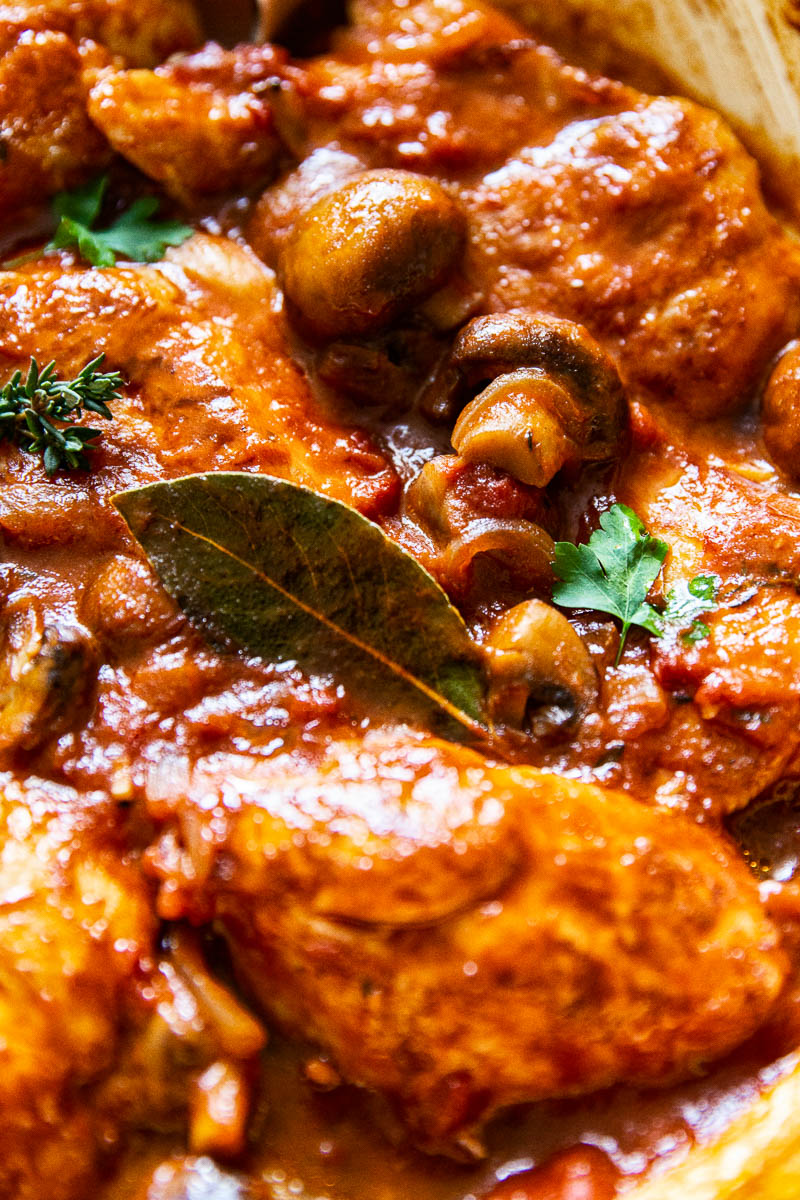 Close up of Chicken Chasseur witih bay leaf in the foreground