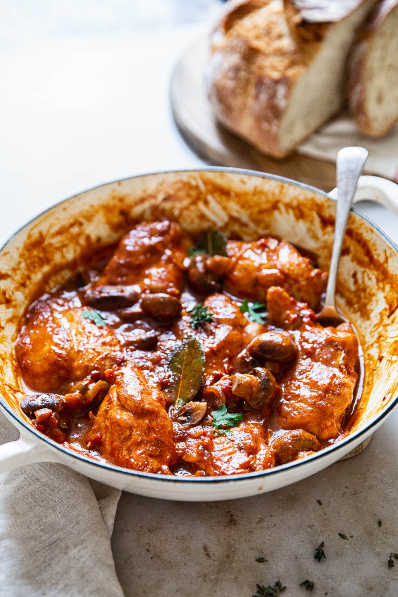 Pan of chicken chasseur with a serving spoon