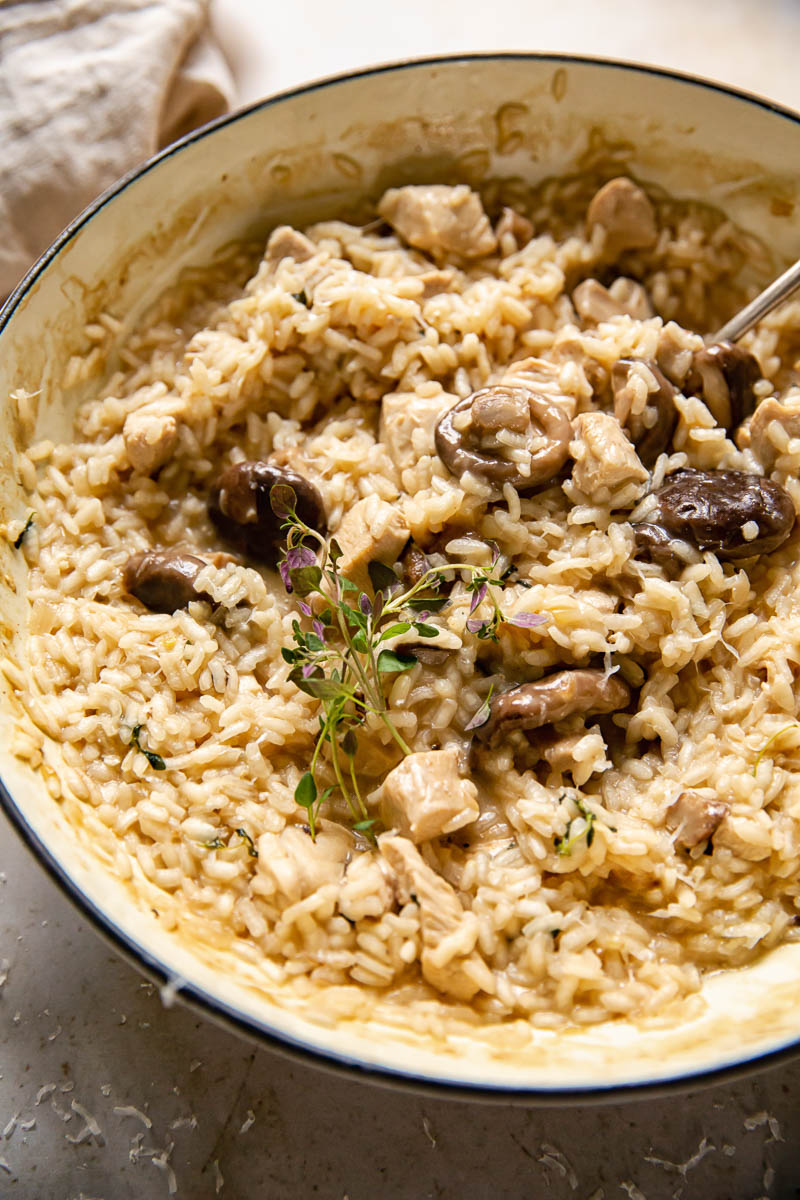 White pan with chicken risotto, with herbs on top