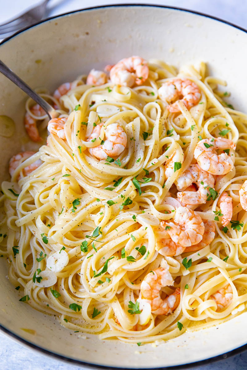 The pasta dish in a cast iron pan with a spoon