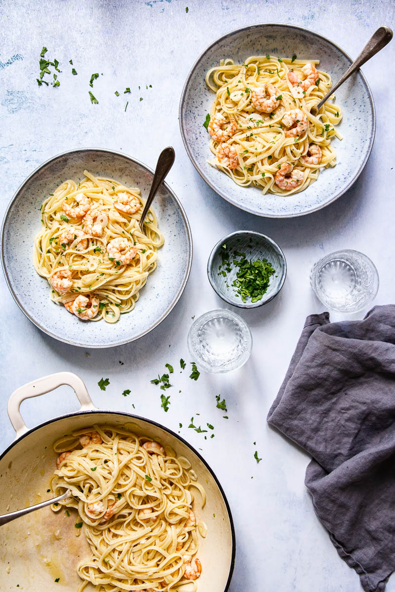 Top down view of pasta in bowls and a cast iron pan