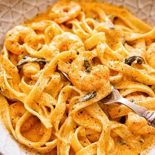 Prawn pasta in creamy tomato sauce in brown bowl