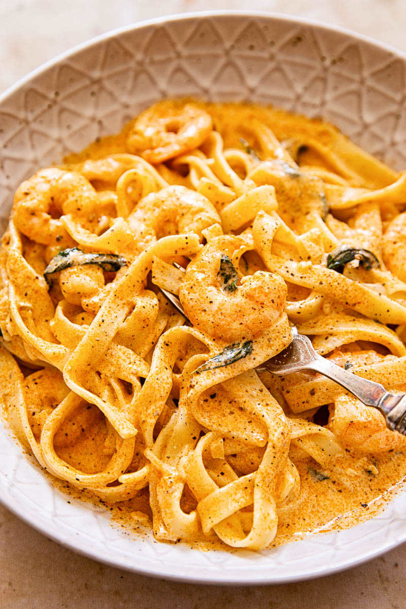 Shrimp pasta in creamy tomato sauce in brown bowl