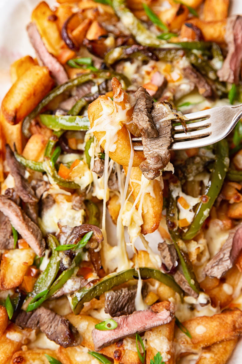 French Fries topped with steak strips, green peppers, onions and melted cheese. 