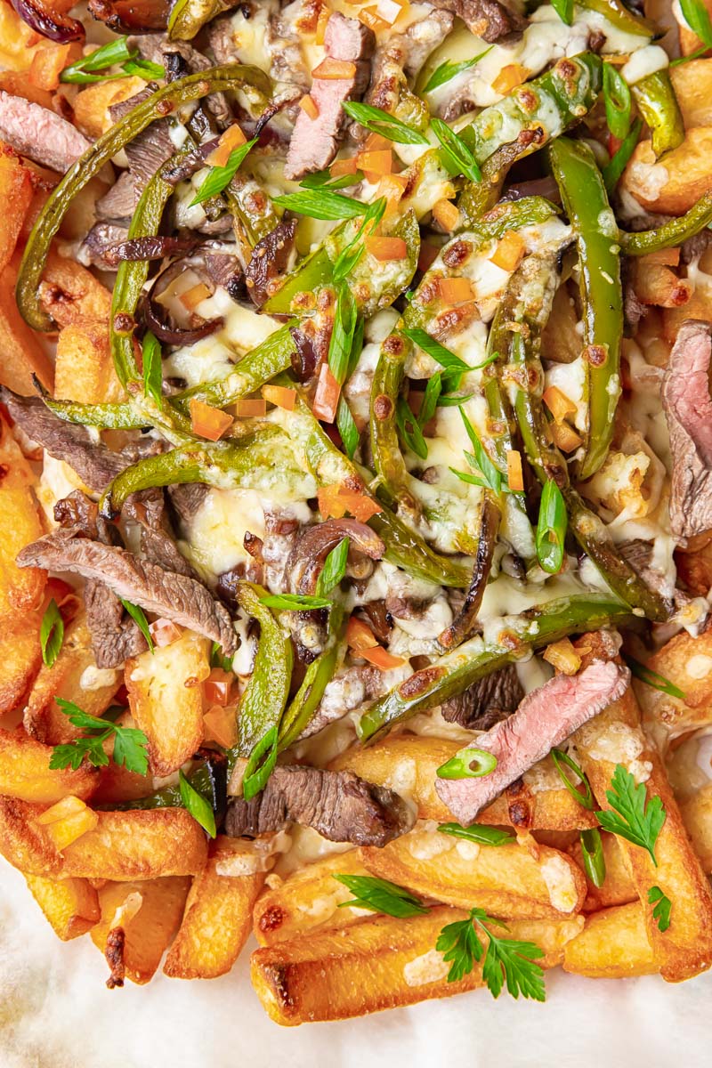 Chunky chips topped with strips of steak, green peppers, onions and melted cheese. 