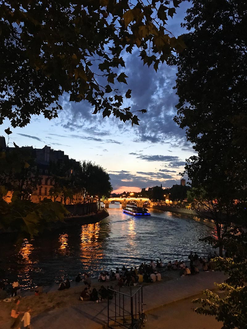 Evening view of the Seine River with lights in the background