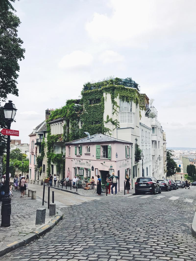 Building in Montmartre covered in ivy, and a cafe