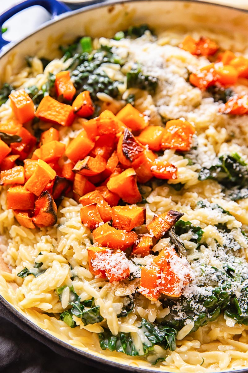 Creamy orzo pasta topped with roasted butternut squash and Parmesan cheese