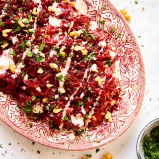 Grated beet salad sprinkled with herbs and walnuts