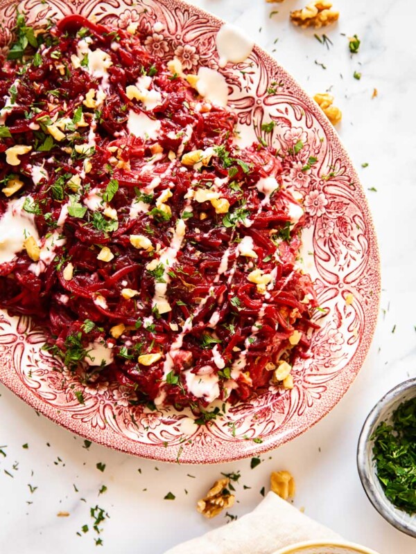 Grated beet salad sprinkled with herbs and walnuts