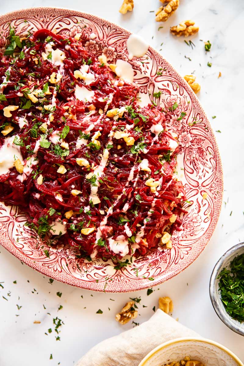 Grated beet salad sprinkled with herbs and walnuts 