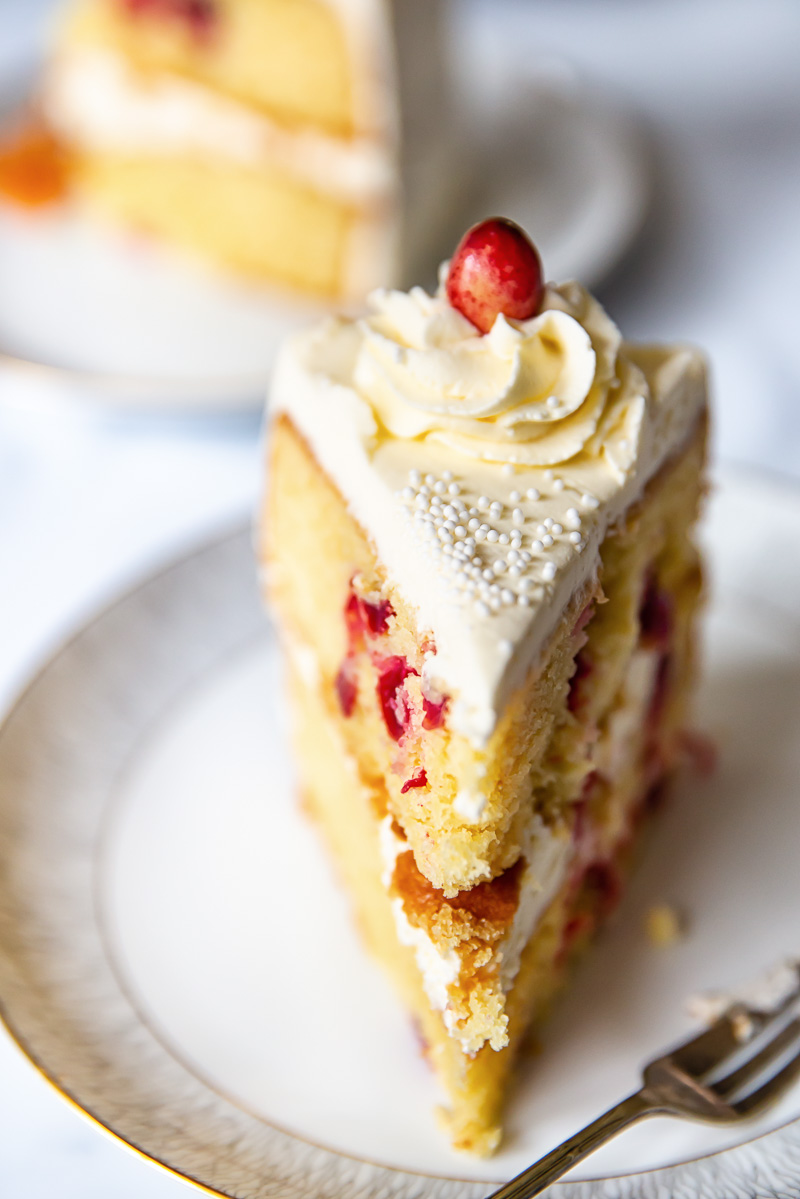 a slice of cranberry cake with a cream cheese frosting rosette on top