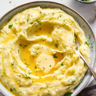 Herby mashed potatoes with melted butter in the center