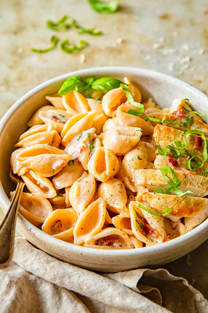 cream pasta sprinkled with basil in a bowl