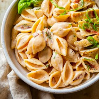 creamy bacon pasta topped with chicken breast and basil