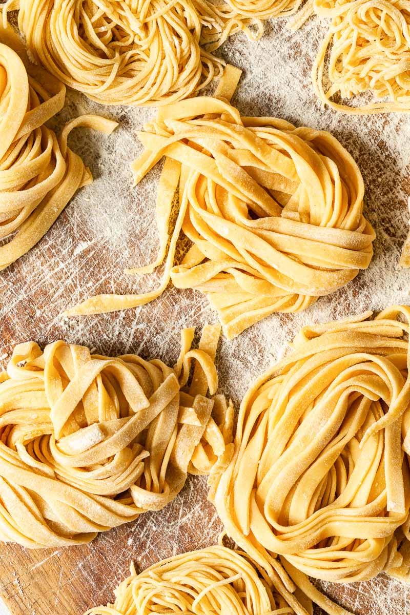 fresh fettuccine pasta on wooden board