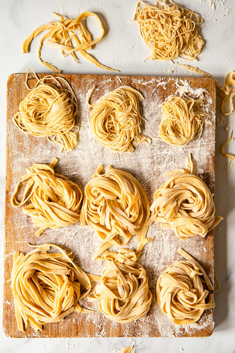 homemade tagliatelle and tagliolini on wooden board