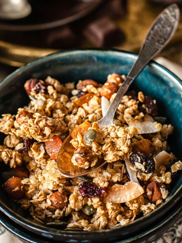 granola in a blue bowl with a spoon in it