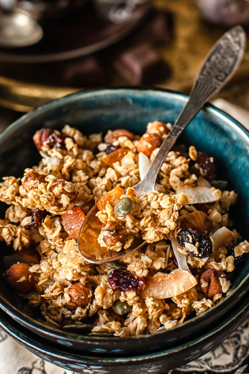 granola in a blue bowl with a spoon in it