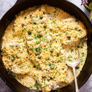 baked fish in cream sauce in black skillet