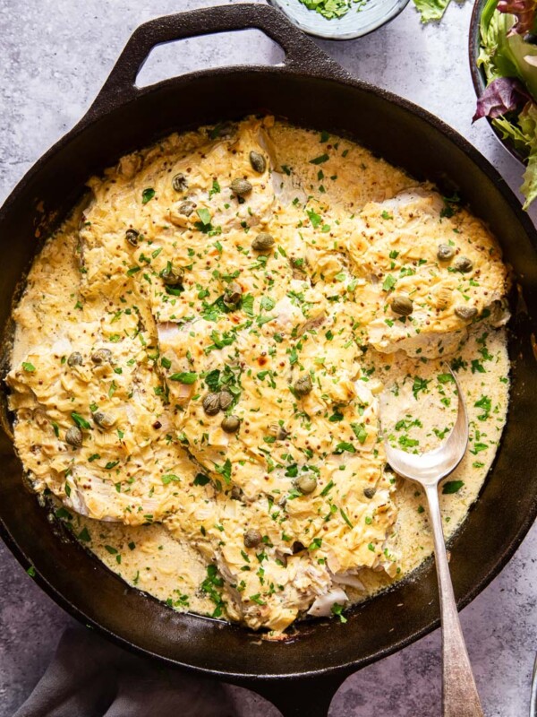 baked fish in cream sauce in black skillet