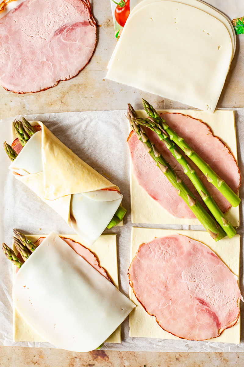 puff pastry squares lined with slices of ham, cheese and asparagus