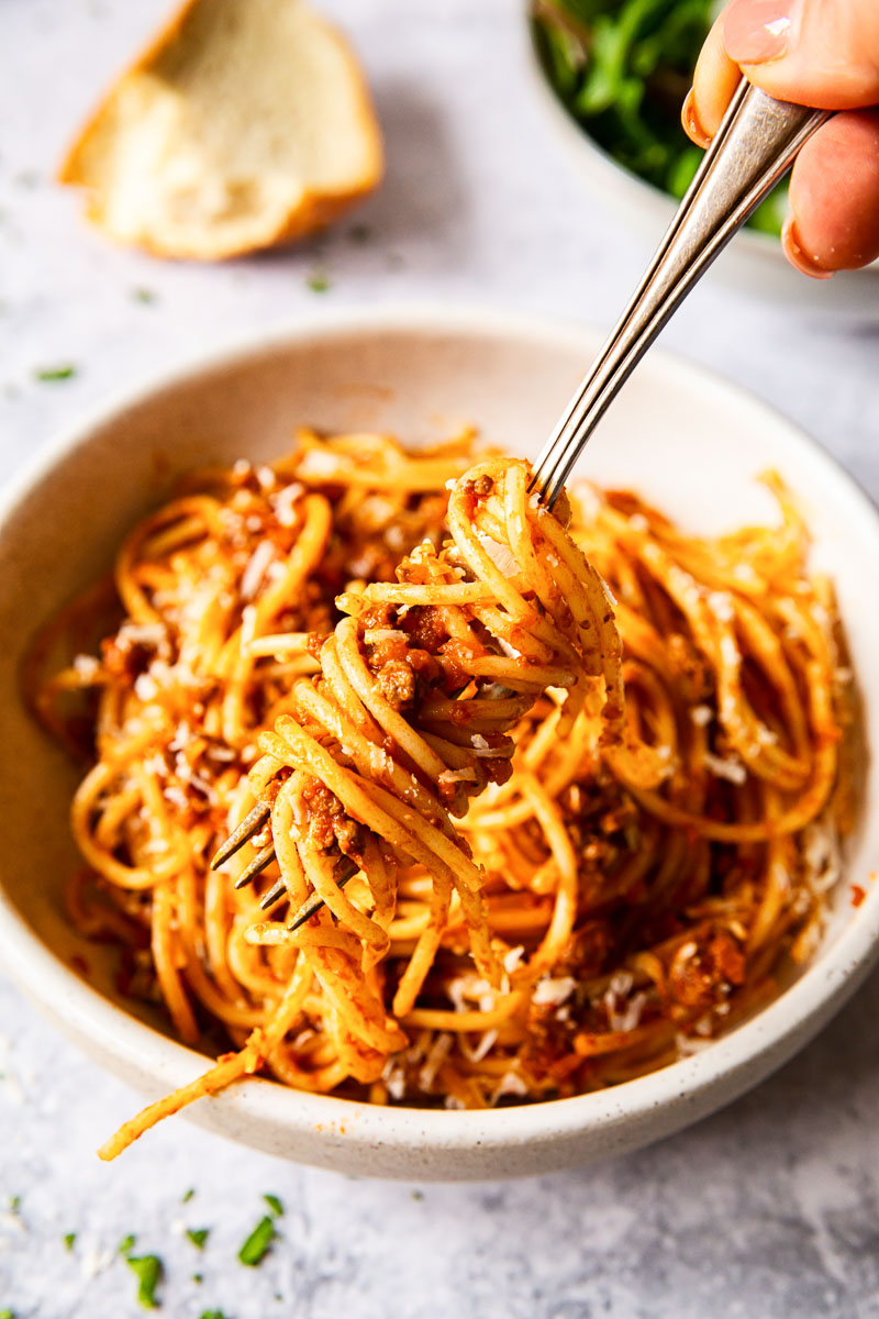 spaghetti twirled around a fork over a bowl