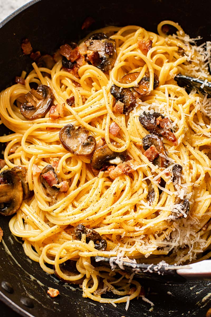 spaghetti carbonara with mushrooms in a pan